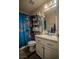 Bathroom with a toilet, a sink, and a blue floral shower curtain at 10049 Fragile Fields St, Las Vegas, NV 89183