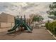 Community playground with green slide, mature trees, and desert landscaping at 10049 Fragile Fields St, Las Vegas, NV 89183