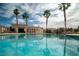 Relaxing community pool area featuring clear blue water, palm trees, and comfortable lounge chairs for residents at 10049 Fragile Fields St, Las Vegas, NV 89183