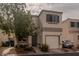 Charming two-story home with a one-car garage and neutral stucco facade, complemented by a tidy front yard and mature tree at 10049 Fragile Fields St, Las Vegas, NV 89183