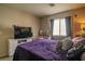 Comfortable main bedroom with a plush bed, soft lighting, and window with curtains at 10049 Fragile Fields St, Las Vegas, NV 89183