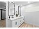 Modern bathroom featuring dual sinks, white cabinets, quartz countertops, and sleek black framed mirrors at 1020 Baker Ave, Las Vegas, NV 89108