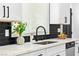 Close up on kitchen with white quartz counters, black hardware and black faucet at 1020 Baker Ave, Las Vegas, NV 89108