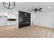 Living room view with fireplace, modern ceiling fan, and adjacent open kitchen space at 1020 Baker Ave, Las Vegas, NV 89108