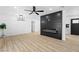 Open-concept living room featuring fireplace, sleek ceiling fan, and wood-look flooring at 1020 Baker Ave, Las Vegas, NV 89108