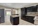 A kitchen with dark cabinets, stainless appliances, and an island is showcased in this well lit scene at 108 Prince Ln, Las Vegas, NV 89110