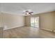Bright living room with wood floors, ceiling fan, and sliding glass doors to the backyard at 108 Prince Ln, Las Vegas, NV 89110