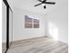 Bright bedroom featuring wood-look floors, ceiling fan, and closet with mirrored sliding doors at 116 Crescent Bay St, Henderson, NV 89012
