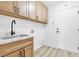Laundry room with sink, overhead cabinets, and a door leading to another part of the house at 116 Crescent Bay St, Henderson, NV 89012