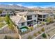 A beautifully landscaped backyard with a pergola-covered lounge, hot tub, and mountain views at 12355 Grey Dunes Ave, Las Vegas, NV 89138