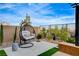 Private backyard featuring a modern hanging chair, desert landscaping, and stylish hardscaping perfect for outdoor living at 12355 Grey Dunes Ave, Las Vegas, NV 89138