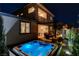 Backyard night view featuring a hot tub, covered patio, and desert landscaping creating a perfect outdoor living space at 12355 Grey Dunes Ave, Las Vegas, NV 89138