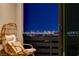 Balcony with comfy wicker chair offering stunning city views at night, a perfect spot to unwind at 12355 Grey Dunes Ave, Las Vegas, NV 89138