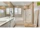 This bathroom features double sinks, a tub, a shower, and wood-look flooring at 12355 Grey Dunes Ave, Las Vegas, NV 89138