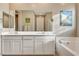This well-lit bathroom includes a double sink vanity and separate tub at 12355 Grey Dunes Ave, Las Vegas, NV 89138