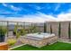 Backyard featuring a modern hot tub with stone surround, artificial turf, and desert landscaping for relaxation at 12355 Grey Dunes Ave, Las Vegas, NV 89138