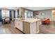 Open-concept kitchen with island, stainless steel appliances, and seamless flow to the dining and living spaces at 12355 Grey Dunes Ave, Las Vegas, NV 89138