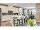 Bright kitchen with white cabinets, island with seating, stylish backsplash, and adjacent dining area at 12355 Grey Dunes Ave, Las Vegas, NV 89138