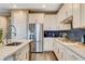 Well-appointed kitchen with stainless steel appliances, white cabinetry, and stylish blue backsplash at 12355 Grey Dunes Ave, Las Vegas, NV 89138