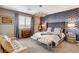 Luxurious bedroom with patterned accent wall, tufted headboard, sitting area, and soft carpeting at 12355 Grey Dunes Ave, Las Vegas, NV 89138