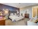 Well-appointed main bedroom featuring patterned accent wall, tufted headboard, and comfortable seating area at 12355 Grey Dunes Ave, Las Vegas, NV 89138