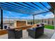 Relaxing patio area with a water feature, comfortable chairs, and a lush backyard view at 12355 Grey Dunes Ave, Las Vegas, NV 89138