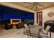 Inviting covered patio featuring a fire feature, ceiling fan, and outdoor dining area at 12355 Grey Dunes Ave, Las Vegas, NV 89138