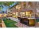 Backyard featuring an outdoor kitchen, mini golf course, and covered patio with a ceiling fan at 1272 Olivia Pkwy, Henderson, NV 89011