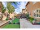 Serene backyard featuring a putting green, mature trees, lush landscaping, and a relaxing outdoor lounge area at 1272 Olivia Pkwy, Henderson, NV 89011