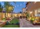 Landscaped backyard with putting green, lush plantings, mature shade trees, and a stone-paved patio at 1272 Olivia Pkwy, Henderson, NV 89011