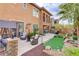 Expansive backyard with an outdoor lounge area, dining set, putting green, and manicured desert landscaping at 1272 Olivia Pkwy, Henderson, NV 89011