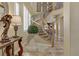 Grand foyer showcasing a curved staircase, elegant decor, and abundant natural light at 1272 Olivia Pkwy, Henderson, NV 89011