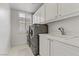 Bright laundry room with white cabinets, a utility sink, and modern washer and dryer at 1272 Olivia Pkwy, Henderson, NV 89011