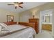 Comfortable main bedroom with wooden furniture, ceiling fan, and an attached bathroom at 1272 Olivia Pkwy, Henderson, NV 89011