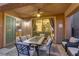 Relaxing covered patio with an outdoor dining set, adjacent to a stylish living room and modern kitchen at 1272 Olivia Pkwy, Henderson, NV 89011