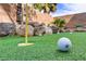 Close-up of putting green highlighting the artificial turf and rock features, set against a stone wall backdrop at 1272 Olivia Pkwy, Henderson, NV 89011