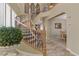 Elegant curved staircase with decorative wrought iron railing and abundant natural light from nearby windows at 1272 Olivia Pkwy, Henderson, NV 89011