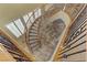 Overhead shot of a winding staircase with an elegant dark wrought iron railing and a light-filled staircase at 1272 Olivia Pkwy, Henderson, NV 89011