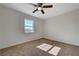 A serene bedroom featuring plush carpeting, a ceiling fan, and a bright window at 1450 Fern St, Pahrump, NV 89060