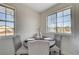 Dining room with a table set for four in front of two windows at 1450 Fern St, Pahrump, NV 89060