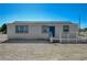 Cozy single-story home with blue door and a white-railed deck under a clear blue sky at 1450 Fern St, Pahrump, NV 89060