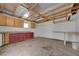 Spacious garage with exposed wood beam ceiling, wooden floors, and custom cabinets for storage at 1450 Fern St, Pahrump, NV 89060