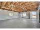 Spacious garage with exposed wood rafters, concrete floors, ample storage, and natural light from windows and an open door at 1450 Fern St, Pahrump, NV 89060