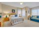 Inviting bedroom with a decorative ceiling fan, comfortable queen bed, sofa, and bright natural lighting at 1766 Baja Ln, Henderson, NV 89012
