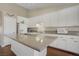 Bright kitchen featuring a large island, granite countertops, white cabinetry, and stainless steel appliances at 1766 Baja Ln, Henderson, NV 89012
