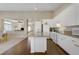 Open-concept kitchen with white cabinets, hardwood floors, and a view into the adjacent living area at 1766 Baja Ln, Henderson, NV 89012