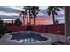 Backyard swimming pool and palm trees silhouetted against a vibrant and colorful sunset sky at 1766 Baja Ln, Henderson, NV 89012