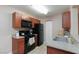 Efficient kitchen featuring dark cabinets, a black range, and durable granite countertops at 2120 Ramrod Ave # 513, Henderson, NV 89014