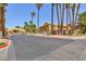 Exterior street view of a well-maintained condo complex with lush landscaping and palm trees against a clear blue sky at 2120 Ramrod Ave # 513, Henderson, NV 89014