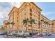 Elegant multi-story building showcasing its architectural design, landscaping, and surrounding palm trees at 2405 W Serene Ave # 703, Las Vegas, NV 89123